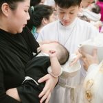 A woman holding a baby in a church