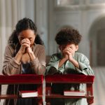 Mother and Daughter Praying in the Church